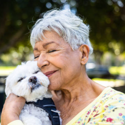 Elderly woman hugging her small dog